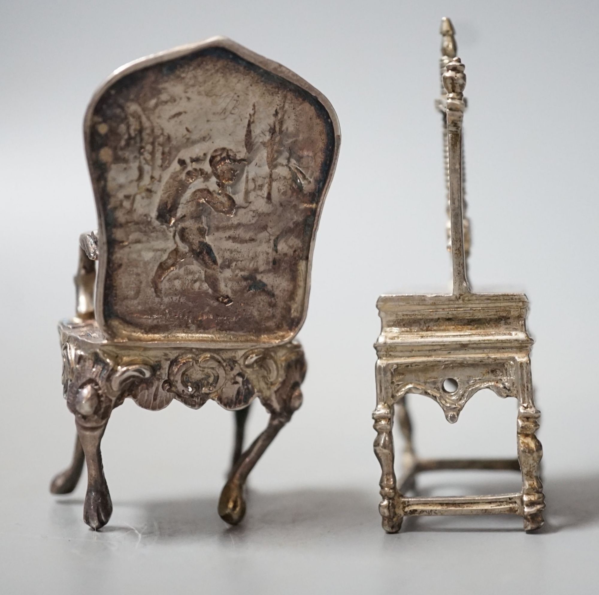 An Edwardian silver miniature model of an armchair, import marks for Glasgow, 1902, 64mm and a white metal model of a press.